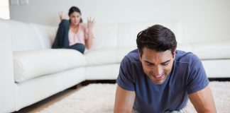 Man using a tablet computer while his girlfriend is getting mad at him
