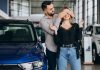 Young couple choosing a car in a car show room