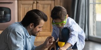 Caring millennial father and preteen son doing funny chemical experiments